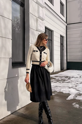 a lady in a black top, a black skirt and a white cardigan